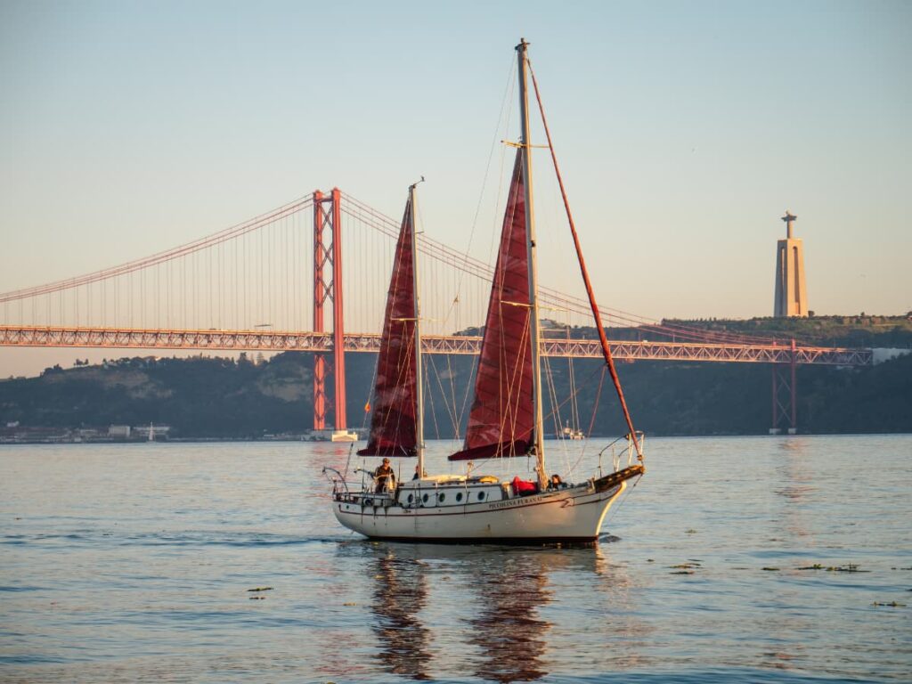 A boat cruising on the River Tagus, in Lisbon, at sunset.